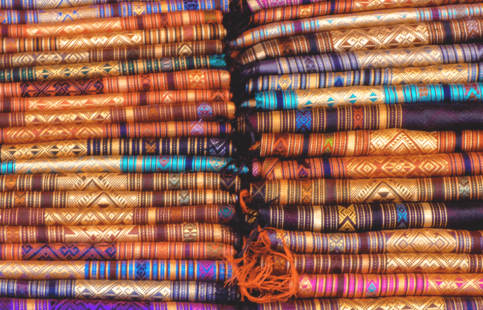 Fabrics in a rainbow of colours are being sold at the night market in Luang Prabang