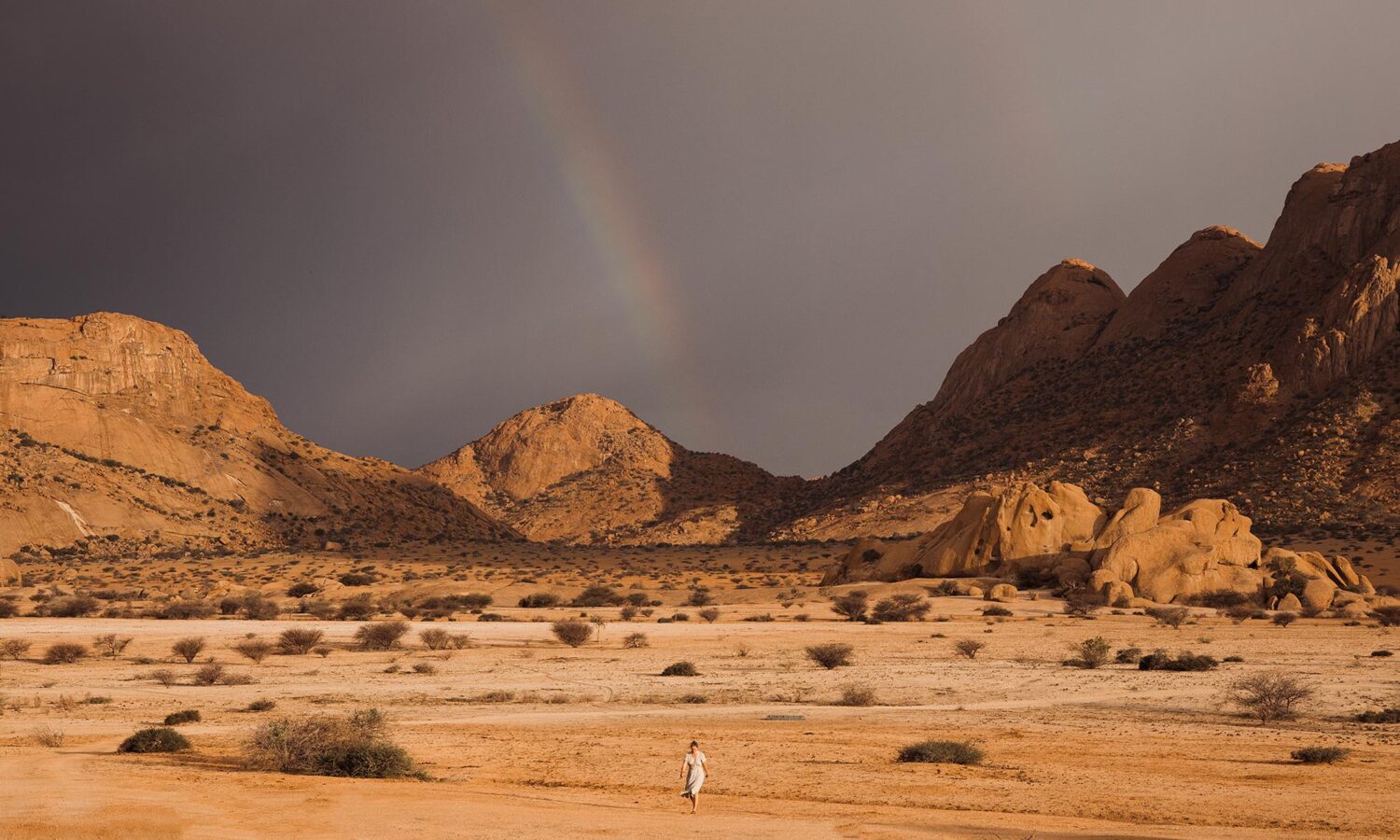 A rainbow welcomes us walking through the desert landscapes from our clamping cabin at the Spitkoppen lodge