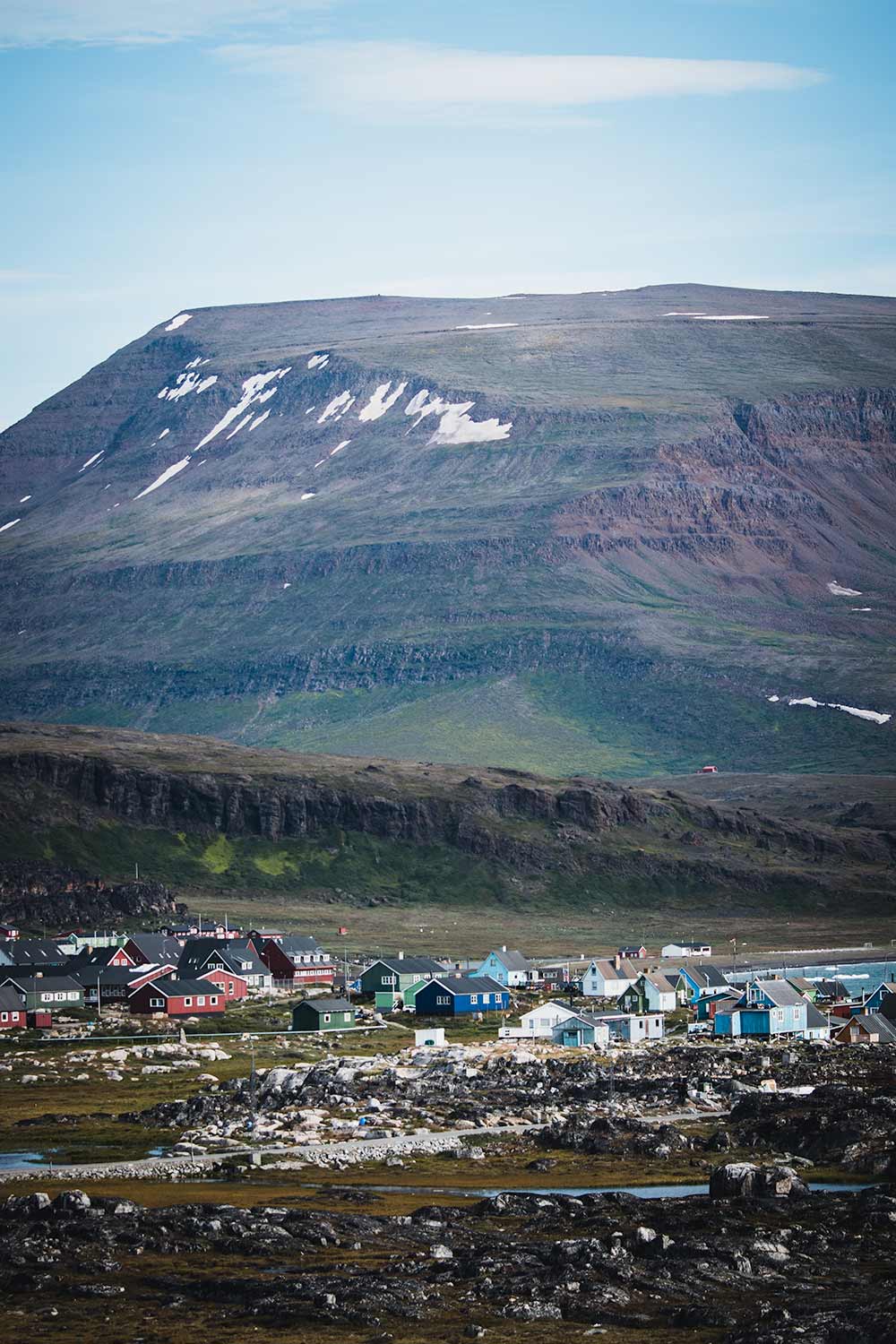 The contrast of colorful houses against Disko Island's pristine landscapes
